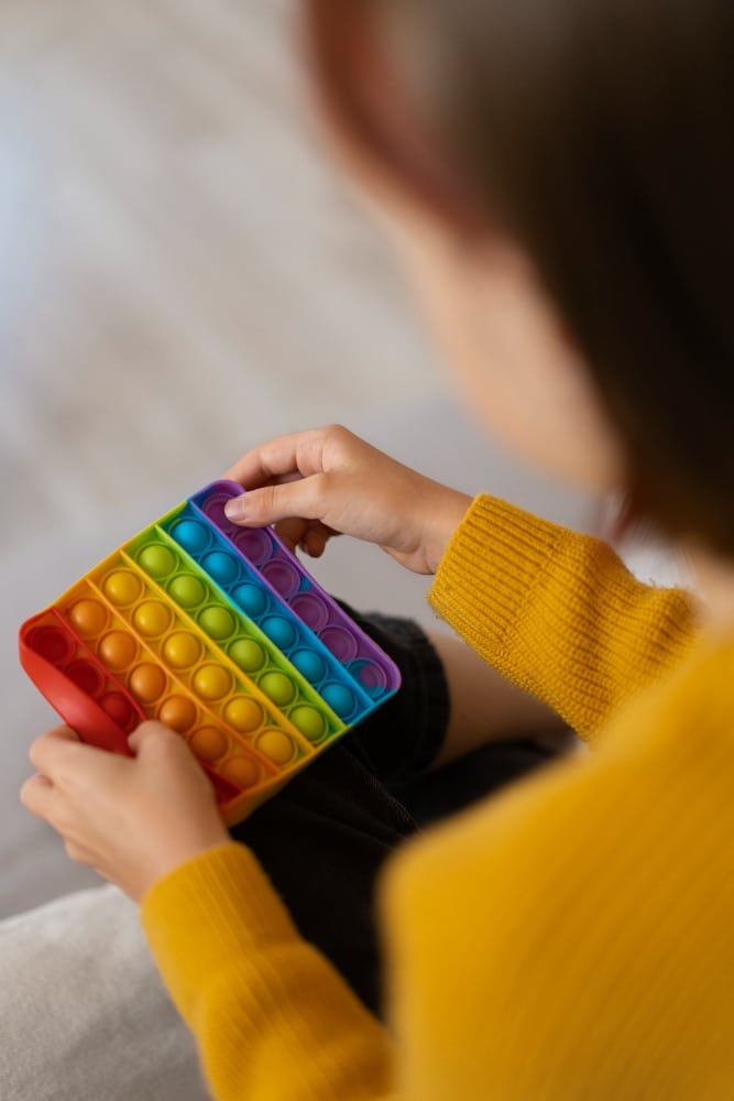 Child playing with colorful pop toy