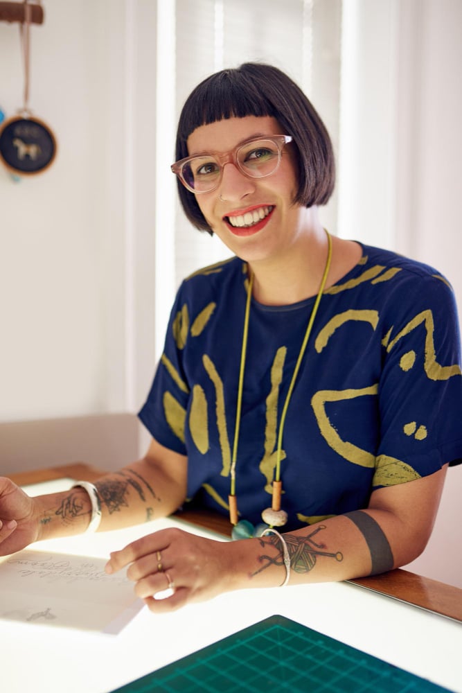 Smiling woman with tattoos and glasses